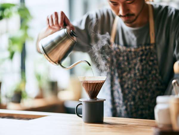 ハンドドリップでコーヒーを淹れるバリスタ