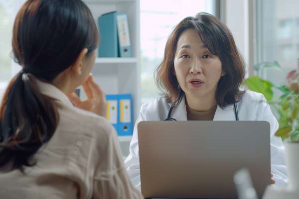 診察室で患者の話を聞く女性医師