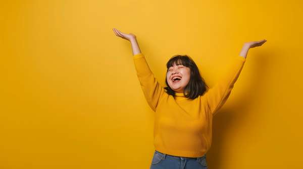 黄色い背景で両手を広げて笑顔の女性
