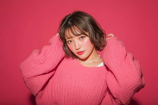 ピンクのニットを着た可愛い日本人女性のポートレート