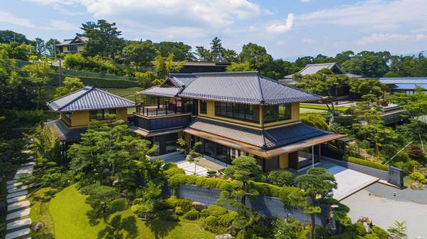 緑豊かな庭園と調和した現代的な日本の邸宅