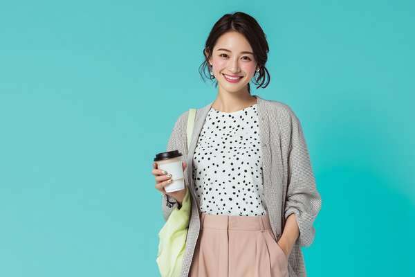 笑顔でコーヒーを持つビジネスウーマン