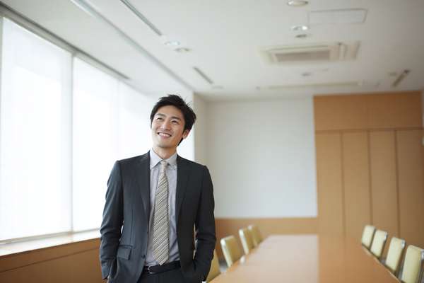 会議室で微笑む日本のビジネスマン