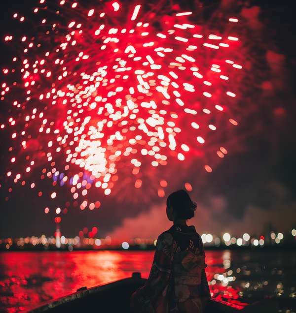 花火を見上げる浴衣姿の女性
