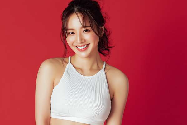 赤い背景で笑顔を見せる女性