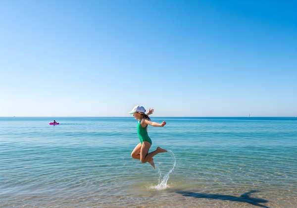 海辺で元気に飛び跳ねる女の子