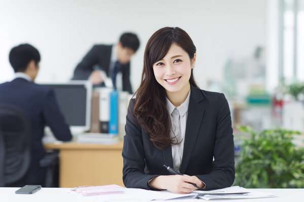 オフィスで微笑む日本人女性ビジネスパーソン