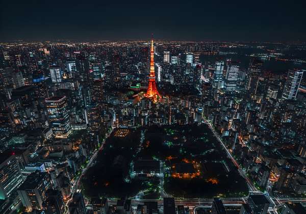 夜の東京タワーと高層ビル群の空撮