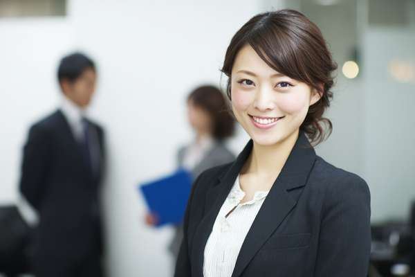 オフィスで微笑む日本人女性ビジネスパーソン