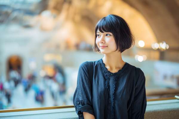 美術館で微笑むショートヘアの女性